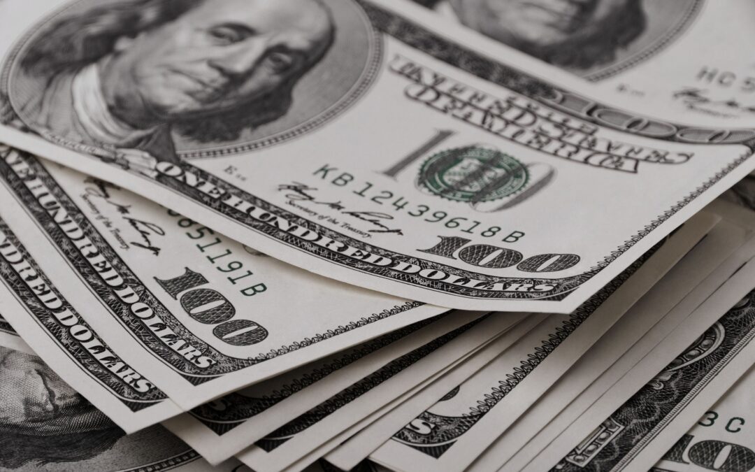 Stack of $100 bills representing financial clarity and improved real estate team's profitability.