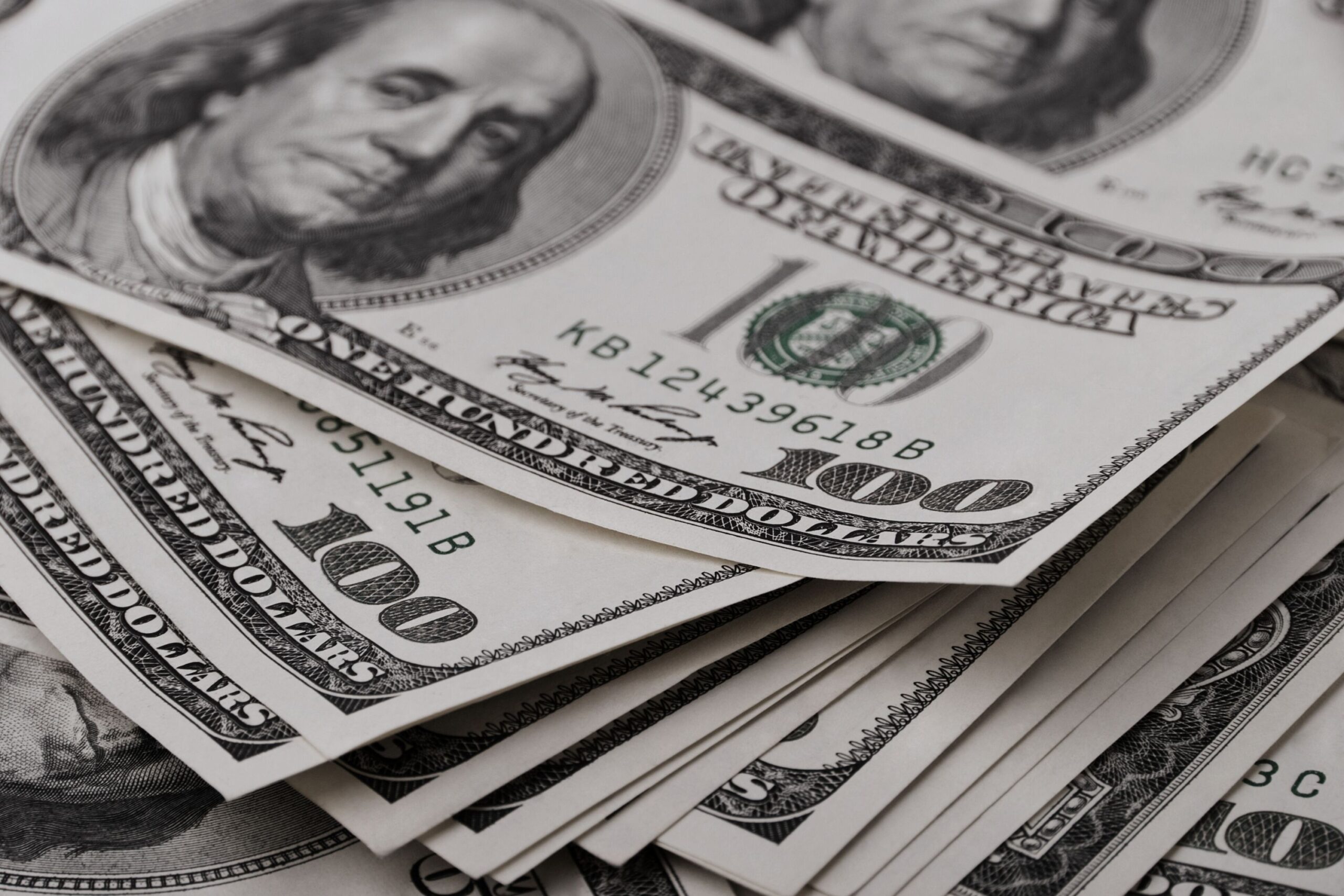 Stack of $100 bills representing financial clarity and improved real estate team profitability.